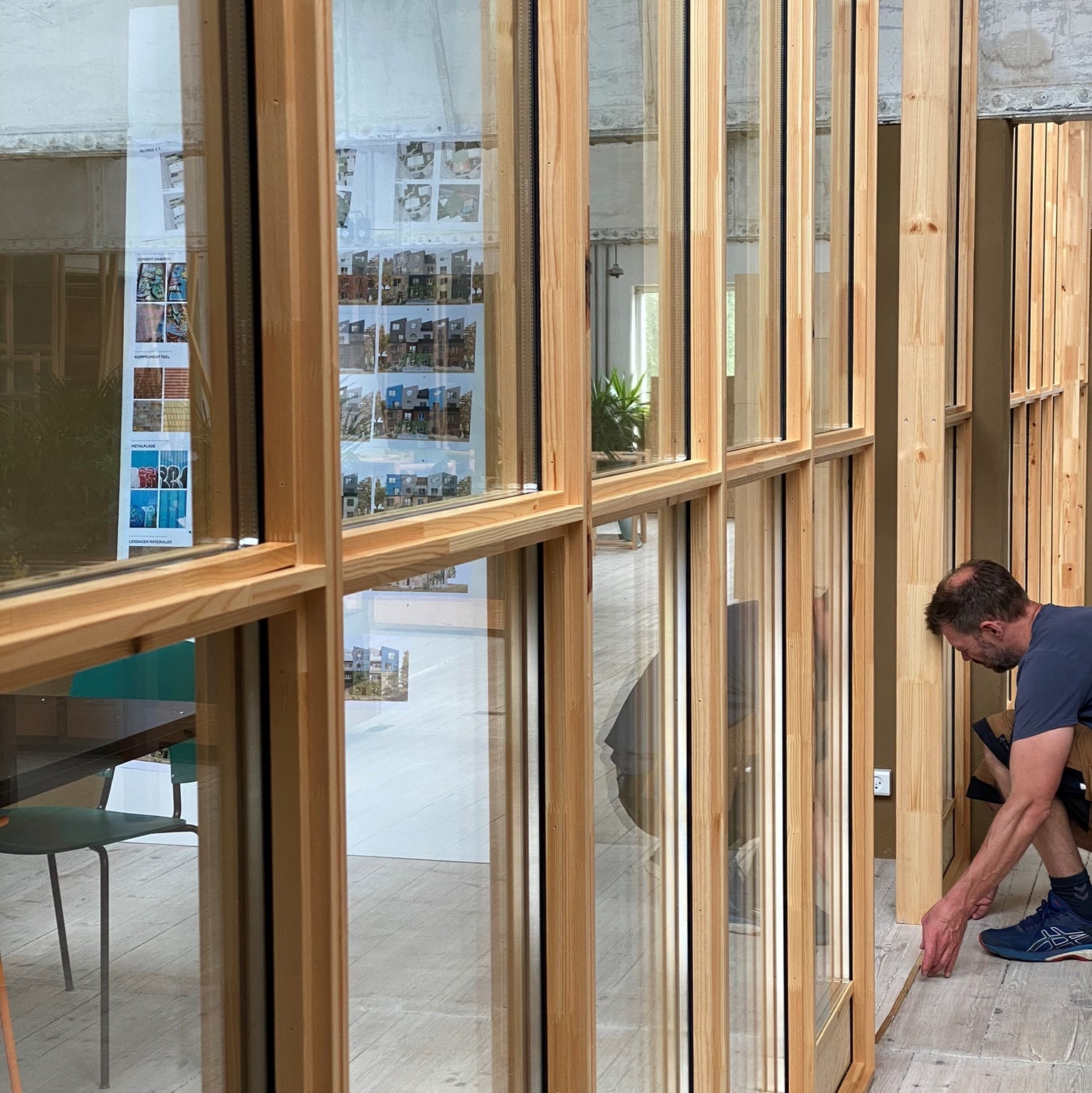 A builder installing the Tystø glass partitioning at Lendager's Office.